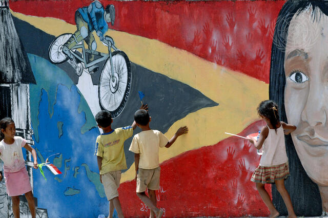 Children Playing in Front of Mural Promoting Tour-de-Timor Cycle Race